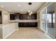 Modern kitchen with dark cabinets, an island, and sliding glass doors at 13717 Ashgrove Cir, Parker, CO 80134