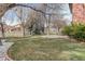 Lush backyard with a manicured lawn, mature trees, and charming landscaping at 1036 Lexington Ave, Westminster, CO 80023