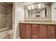 Bathroom featuring a dual sink vanity with granite counters and tiled shower at 1036 Lexington Ave, Westminster, CO 80023