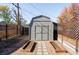 Backyard outbuilding surrounded by privacy fencing and stone pavers at 2774 W Irvington Pl, Denver, CO 80219