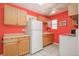 Bright kitchen with wood cabinets, white appliances, and tiled floors provides a functional cooking space at 2774 W Irvington Pl, Denver, CO 80219