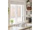 Close-up of a kitchen sink with a modern faucet, white cabinets, and open shelves adorned with plants and dishware at 2774 W Irvington Pl, Denver, CO 80219