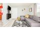 Living room featuring a comfortable sectional sofa, decorative wall plants, and a view of the adjacent kitchen at 2774 W Irvington Pl, Denver, CO 80219