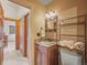 Cozy bathroom with a granite vanity and a shelved tower for storage and towels at 4198 Timbervale Dr, Evergreen, CO 80439