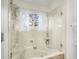Bright bathroom featuring tub and shower with glass door and window at 4198 Timbervale Dr, Evergreen, CO 80439