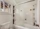 Bright bathroom featuring a glass-enclosed tub-shower, built in shelving, and window at 4198 Timbervale Dr, Evergreen, CO 80439