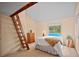 Cozy bedroom with a carpet flooring, neutral walls, wood dresser, and an accent ladder at 4198 Timbervale Dr, Evergreen, CO 80439