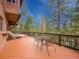 Relax on this deck featuring outdoor seating with a view of the tall trees and blue sky at 4198 Timbervale Dr, Evergreen, CO 80439