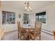 Inviting dining area with views of a lovely outdoor setting, featuring natural wood furnishings and décor at 4198 Timbervale Dr, Evergreen, CO 80439