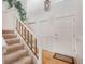 A welcoming entryway with light carpeted stairs, wood trim, and a front door with decorative paneling at 4198 Timbervale Dr, Evergreen, CO 80439