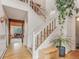 Inviting entryway features wood floors and trim, stairway, and a view into the home's light-filled living spaces at 4198 Timbervale Dr, Evergreen, CO 80439