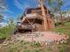 Rustic cabin with wood siding, a rock garden, and multiple decks for outdoor enjoyment at 4198 Timbervale Dr, Evergreen, CO 80439
