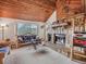 Cozy living room highlighting a beautiful stone fireplace, wood accents, and views to the exterior at 4198 Timbervale Dr, Evergreen, CO 80439