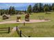 Community playground with a slide, swing set, and picnic table surrounded by trees, grass, and a wooden fence at 4198 Timbervale Dr, Evergreen, CO 80439