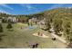 Wide aerial showcasing tennis court, playground, and charming outbuildings on expansive grounds at 4198 Timbervale Dr, Evergreen, CO 80439