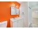 Bright bathroom featuring a vanity, mirror, vibrant accent wall, and a walk-in shower at 1111 Monroe St, Denver, CO 80206