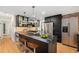 Modern kitchen with an island, stainless steel appliances, stylish bar stools, and hardwood floors at 1111 Monroe St, Denver, CO 80206
