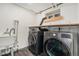 Laundry room with modern washer, dryer, utility sink and ample shelf storage space at 1111 Monroe St, Denver, CO 80206