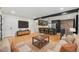 Open-concept living room with hardwood floors, a brick wall accent, and a modern kitchen view at 1111 Monroe St, Denver, CO 80206
