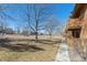 Ground-level backyard shows a grassy area with mature trees behind the unit at 3335 S Ammons St # 103, Lakewood, CO 80227