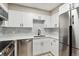 Modern kitchen with stainless steel appliances, and white cabinets with backsplash at 3335 S Ammons St # 103, Lakewood, CO 80227