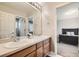 Bright bathroom featuring a double vanity, large mirror, and an adjacent bedroom, offering both convenience and style at 13901 Quail Ridge Dr, Broomfield, CO 80020