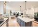 Open-concept kitchen with a large island, white cabinetry, modern pendant lighting, and hardwood floors at 13901 Quail Ridge Dr, Broomfield, CO 80020