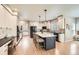 Bright kitchen featuring white cabinetry, large island, modern appliances, and hardwood floors at 13901 Quail Ridge Dr, Broomfield, CO 80020