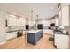 Well-lit kitchen features white cabinets, a blue island with quartz countertops, and stainless steel appliances at 13901 Quail Ridge Dr, Broomfield, CO 80020