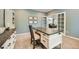 Stylish home office with custom desk and a view into the living room through glass pane doors at 13901 Quail Ridge Dr, Broomfield, CO 80020