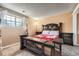 Bedroom featuring a comfortable bed with ornate wood accents, soft carpet, and a bright window at 16333 E Carolina Dr, Aurora, CO 80017