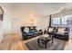 Inviting living room featuring a stylish rug, comfortable leather seating, and hardwood flooring at 16333 E Carolina Dr, Aurora, CO 80017