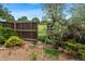 Wood fence surrounds a large backyard with an unlocked gate overlooking a field and residential home in the distance at 8764 W 95Th Ave, Broomfield, CO 80021