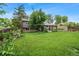 Spacious green backyard with a gray house, covered patio and shed surrounded by grass at 8764 W 95Th Ave, Broomfield, CO 80021