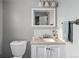 This bathroom has a toilet and sink with a mirror above the sink and a window to the left at 8764 W 95Th Ave, Broomfield, CO 80021