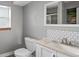 This bathroom has a toilet and sink with a mirror above the sink and a window to the left at 8764 W 95Th Ave, Broomfield, CO 80021