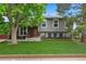 Beautiful two-story home with a well-manicured lawn, brick accents, and inviting front porch with a red chair at 8764 W 95Th Ave, Broomfield, CO 80021