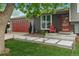 Charming home featuring a red garage door, brick accents, and modern landscaping with concrete pavers and solar lights at 8764 W 95Th Ave, Broomfield, CO 80021