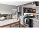 Open kitchen with stainless appliances, stone countertops, wooden beam, hardwood floors, and bar stool seating at 8764 W 95Th Ave, Broomfield, CO 80021