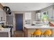 Well-lit kitchen featuring white countertops, stainless steel appliances, and a cozy breakfast bar with yellow chairs at 8764 W 95Th Ave, Broomfield, CO 80021