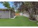 Sideyard showcases lush artificial lawn and privacy fencing with a convenient storage shed at 1746 Shavano St, Longmont, CO 80504