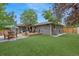 Spacious backyard featuring an artificial lawn, a deck with a pergola, and a separate patio area at 1746 Shavano St, Longmont, CO 80504