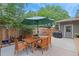 Outdoor dining area with a wooden table, chairs, a shade umbrella, and a barbecue grill at 1746 Shavano St, Longmont, CO 80504