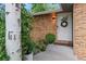 Inviting front porch with brick facade, potted plants, and a decorative wreath on the front door at 1746 Shavano St, Longmont, CO 80504