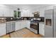 Modern kitchen featuring white cabinets, stainless steel appliances, and stylish backsplash at 1746 Shavano St, Longmont, CO 80504