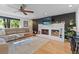 Bright living room with a white brick fireplace, modern fan, hardwood flooring, and lots of light at 1746 Shavano St, Longmont, CO 80504