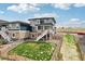 Aerial view of a large backyard with lush green lawn, fences and deck with stairs at 17843 W 93Rd Pl, Arvada, CO 80007