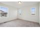 A bright bedroom with neutral carpeting, three windows, and ample natural light at 17843 W 93Rd Pl, Arvada, CO 80007