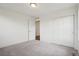 A bright bedroom features neutral carpeting, double closets, and an ensuite bathroom at 17843 W 93Rd Pl, Arvada, CO 80007