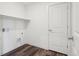Bright laundry area featuring wood-look flooring, shelf, hookups, and a white paneled door at 17843 W 93Rd Pl, Arvada, CO 80007